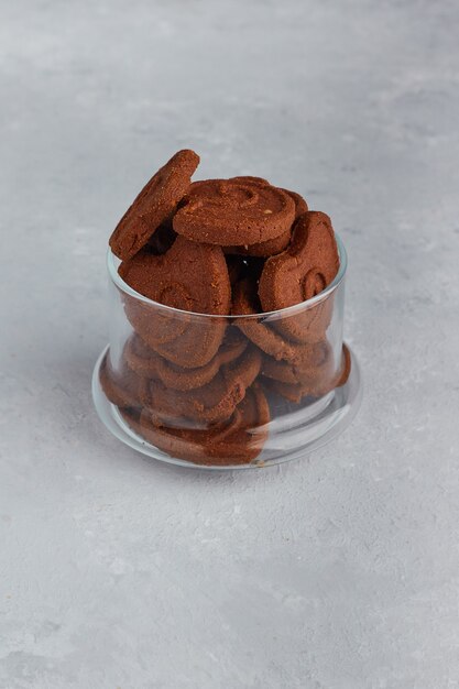 Galletas de chocolate en una taza de vidrio en el medio.