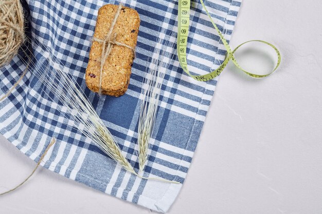 Galletas y cinta métrica sobre un fondo blanco con mantel. Foto de alta calidad