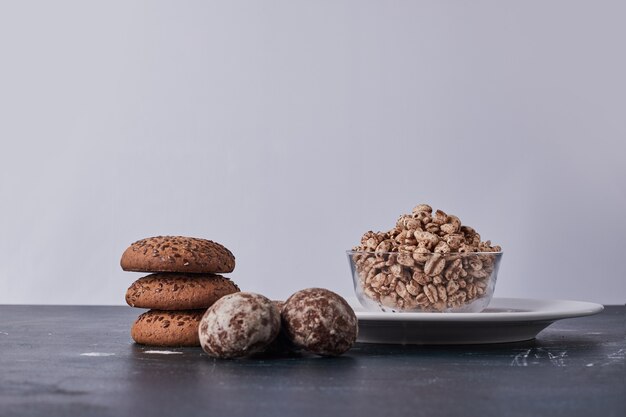 Galletas con comino, avena y pan de jengibre con palomitas de trigo alrededor.