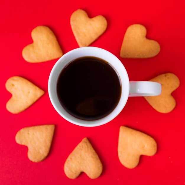 Galletas de corazón con taza de café en la mesa