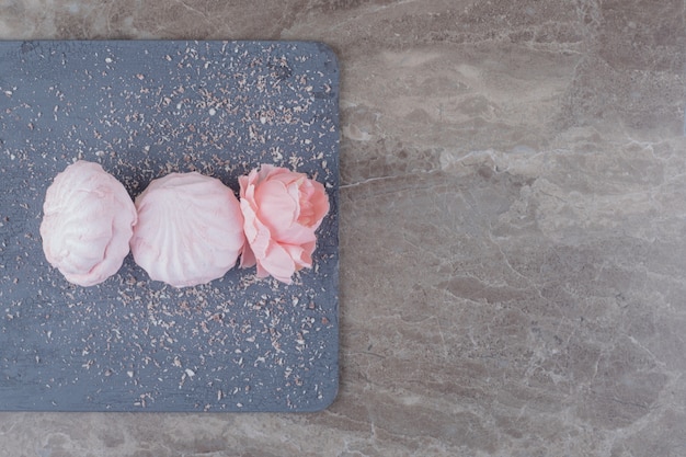 Foto gratuita galletas y una corola de flores sobre una placa de mármol