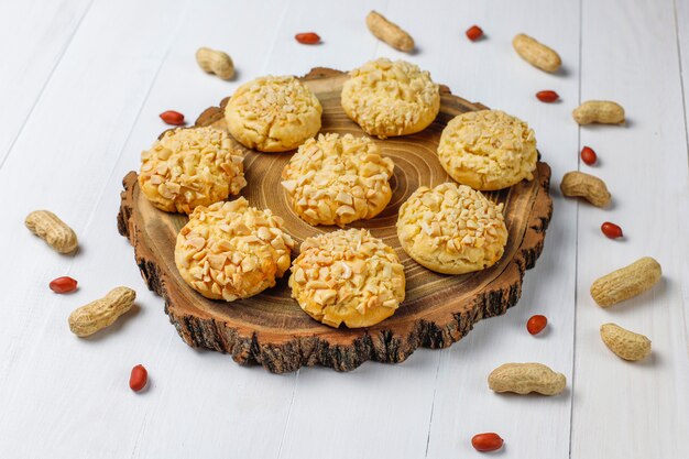 Galletas crujientes caseras con maní en la mesa de madera blanca