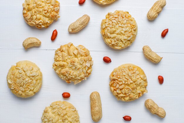 Galletas crujientes caseras con maní en la mesa de madera blanca