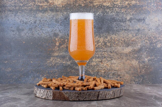 Galletas crujientes con cerveza en trozo de madera