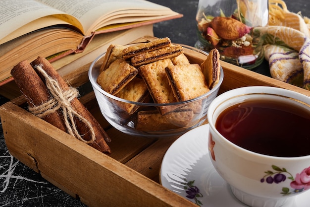 Galletas crujientes con relleno de chocolate con una taza de té.