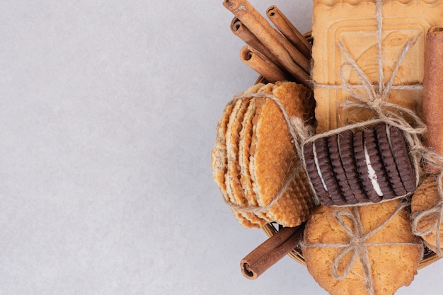 Galletas en cuerda con canela sobre superficie blanca