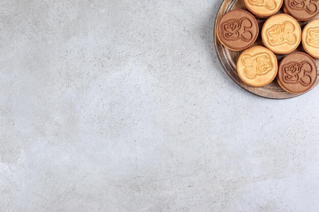 Galletas decoradas sobre tabla de madera en fondo de mármol. Foto de alta calidad