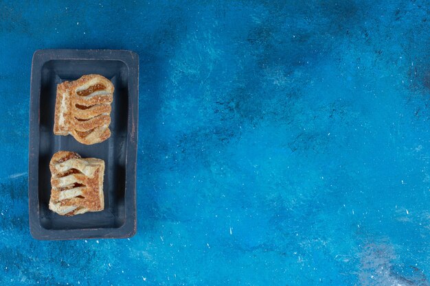 Galletas con dientes en el tablero, sobre el fondo azul. Foto de alta calidad