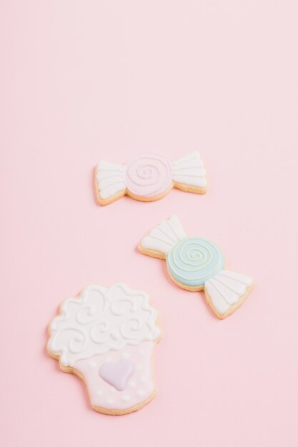 Galletas de diferente forma sobre fondo rosa