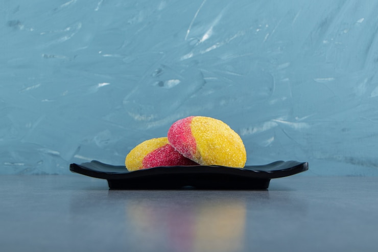 Foto gratuito galletas de dos colores en placa negra.