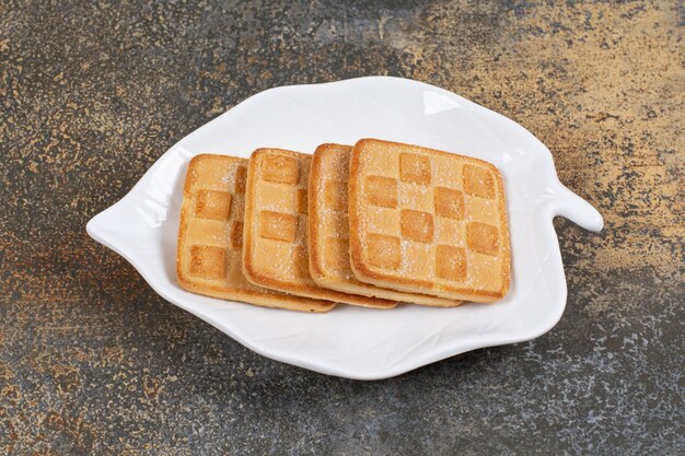 Foto gratuita galletas dulces cuadradas en placa en forma de hoja.