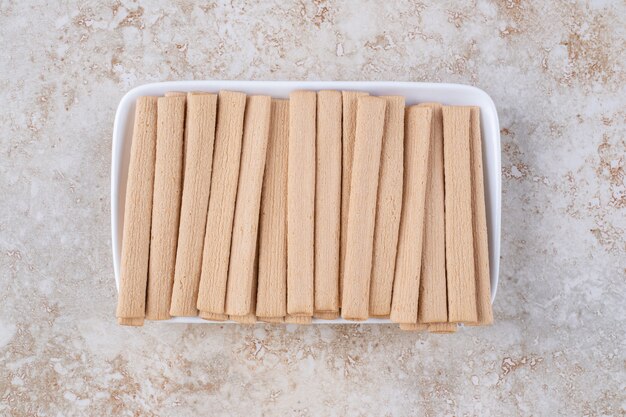 Galletas dulces en un plato, sobre la mesa de mármol.