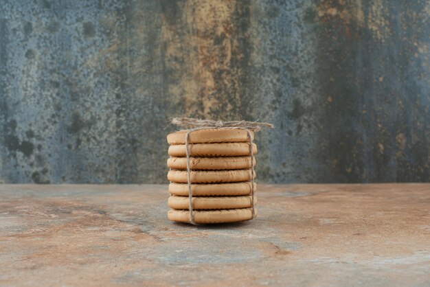 Galletas dulces redondas en cuerda sobre fondo de mármol