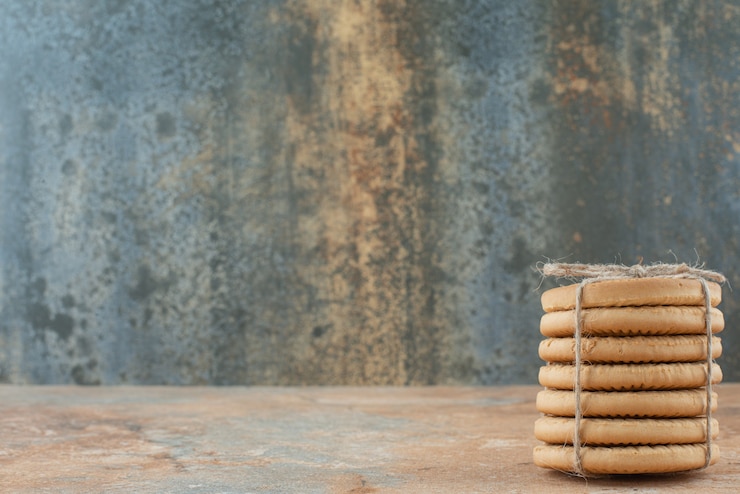 Foto gratuito galletas dulces redondas en cuerda sobre fondo de mármol