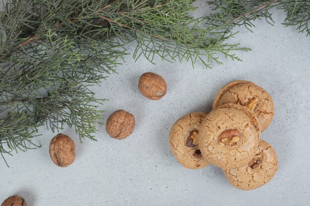 Galletas dulces redondas con nueces sobre superficie blanca