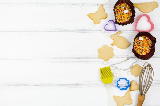 Foto gratuita galletas con forma animal con utensilios de cocina en mesa de madera.