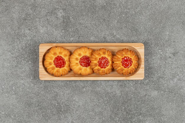 Galletas con forma de flor con gelatina sobre plancha de madera