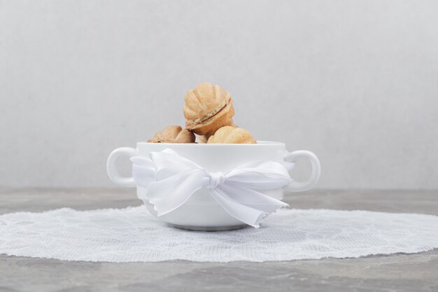 Galletas con forma de nuez en un tazón blanco.