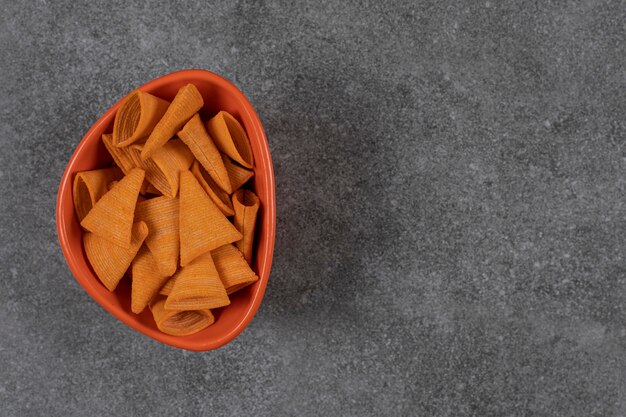 Galletas en forma de triángulo en tazón de fuente naranja.