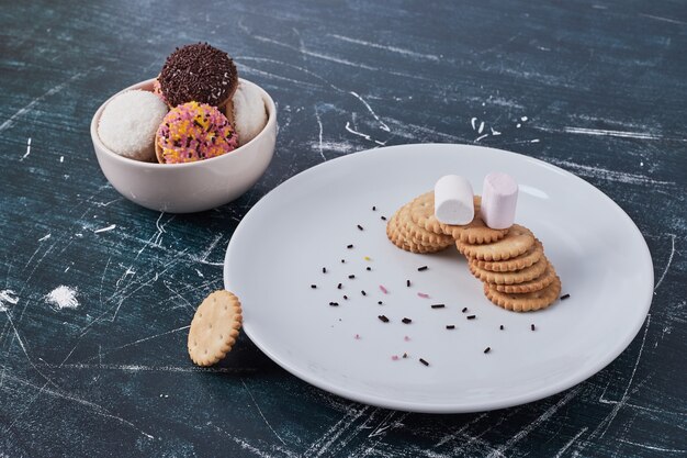 Galletas con galletas de malvavisco en platos blancos, vista superior.