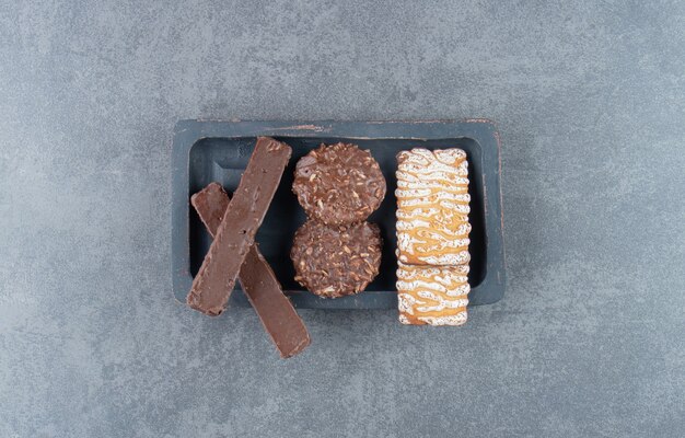 Foto gratuita galletas con galletas redondas de chocolate sobre un tablero oscuro