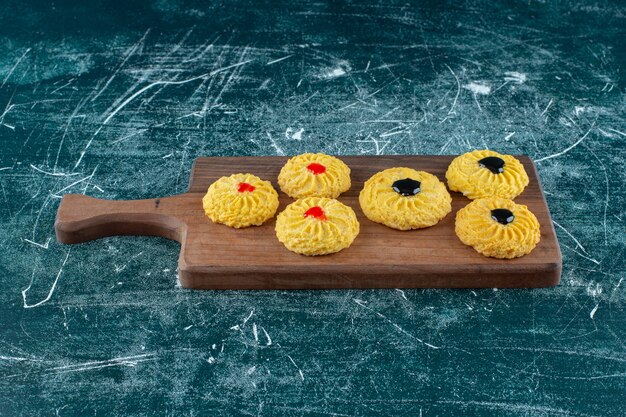 Galletas glaseadas sobre una tabla de cortar, sobre el fondo azul. Foto de alta calidad