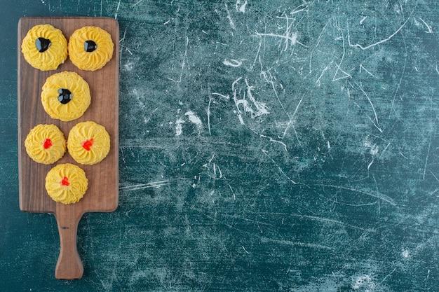 Galletas glaseadas sobre una tabla de cortar, sobre el fondo azul. Foto de alta calidad