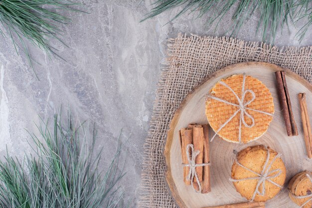 Galletas de gofres en una tabla de madera con palitos de canela