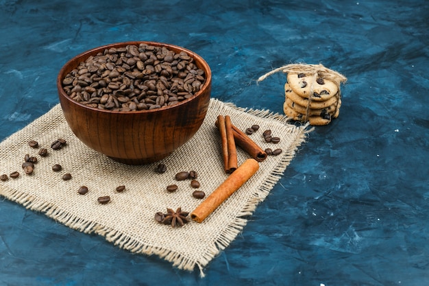 Galletas y granos de café sobre un fondo azul oscuro