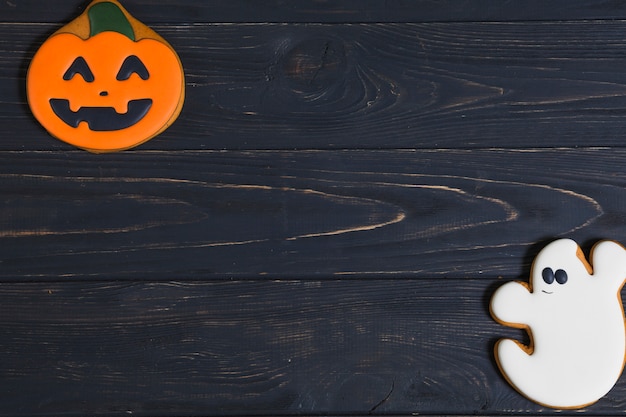 Galletas de Halloween calabaza y fantasma en el escritorio de madera