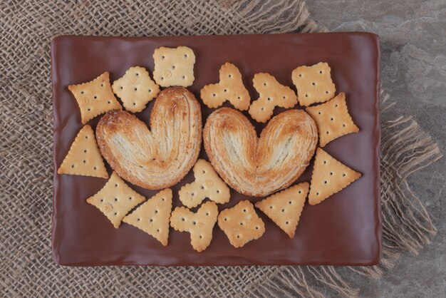 Galletas hojaldradas y paquetes de galletas en una bandeja de mármol