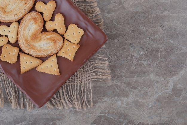 Galletas hojaldradas y paquetes de galletas en una bandeja de mármol