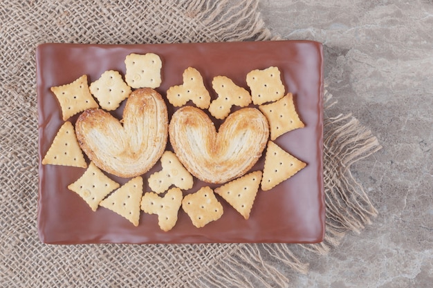 Foto gratuita galletas hojaldradas y paquetes de galletas en una bandeja de mármol