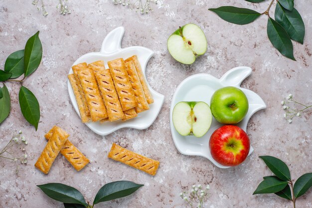 Galletas de hojaldre de manzana en plato en forma de manzana con manzanas frescas