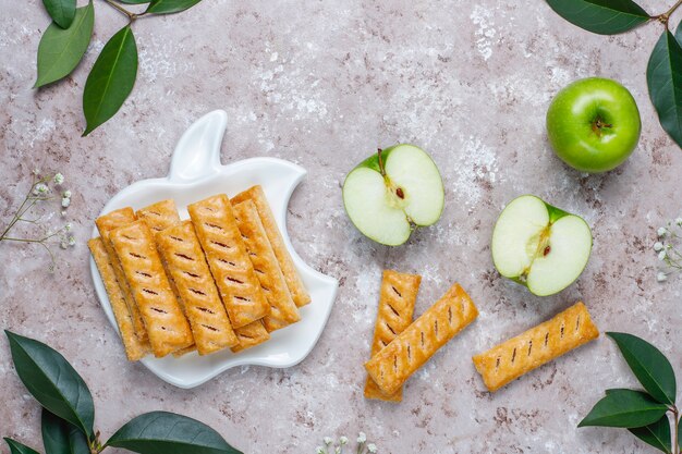 Galletas de hojaldre de manzana en plato en forma de manzana con manzanas frescas