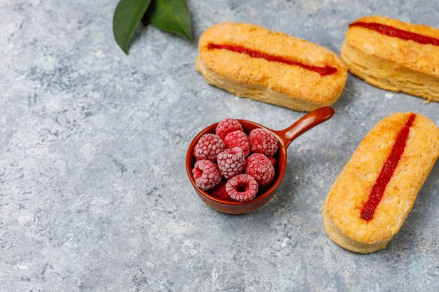 Galletas de hojaldre con mermelada de frambuesa y frambuesas congeladas a la luz