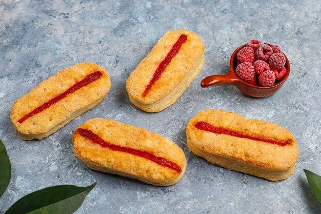 Galletas de hojaldre con mermelada de frambuesa y frambuesas congeladas a la luz