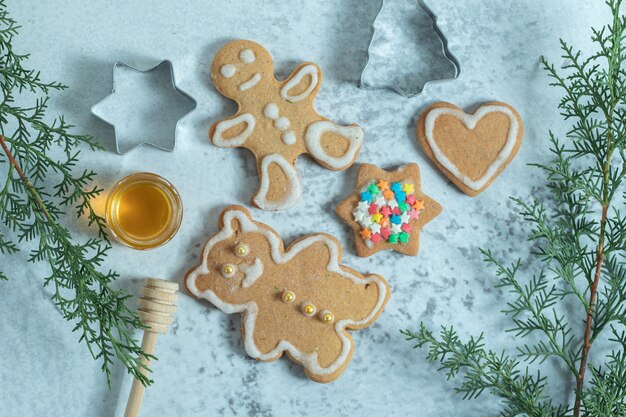 Galletas de jengibre en blanco con ramas de pino.