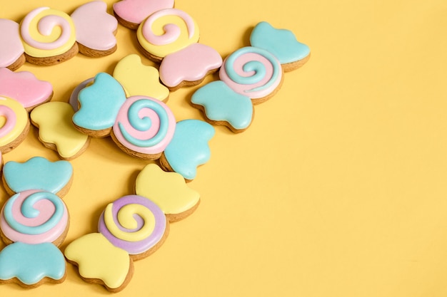 Galletas de jengibre de colores en forma de caramelos en glaseado.