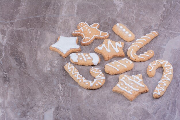 Foto gratuita galletas de jengibre en forma de estrella, palo y ovales sobre mármol.