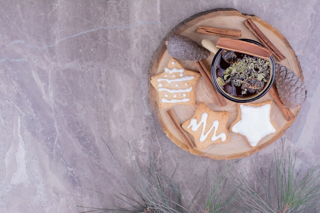 Galletas de jengibre en forma de estrella con una taza de té de hierbas y canela.