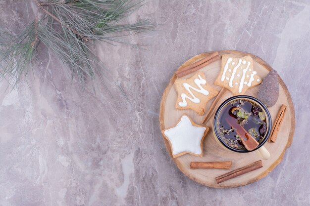 Galletas de jengibre en forma de estrella con una taza de té de hierbas y canela.