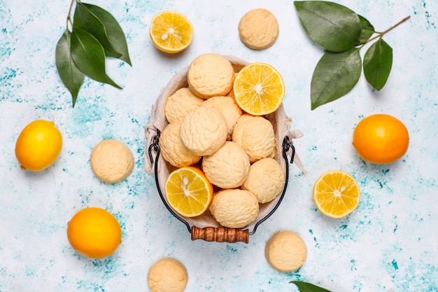 Galletas de limón caseras con limones en superficie clara