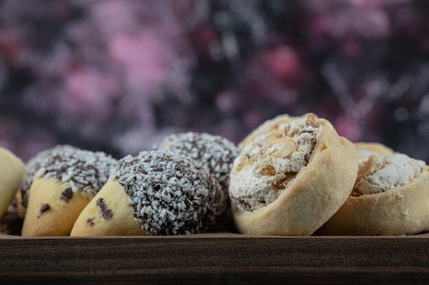 Galletas de mantequilla crujientes con azúcar en polvo en bandeja de madera