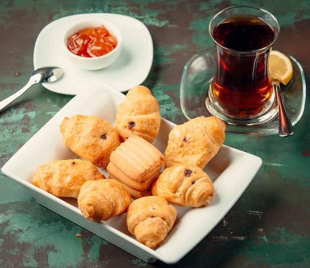 galletas de mantequilla con pasas servidas con té y mermelada