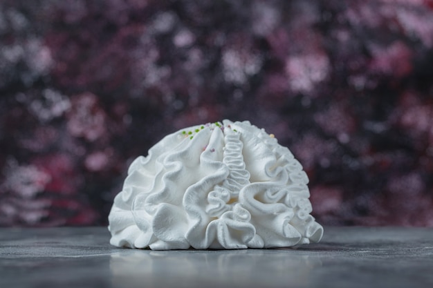 Galletas de merengue floral blanco sobre la mesa.