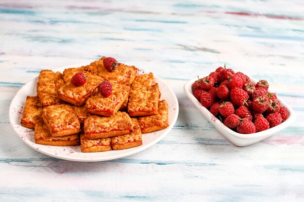 Galletas de mermelada de frambuesa deliciosas dulces con frambuesas maduras, vista superior