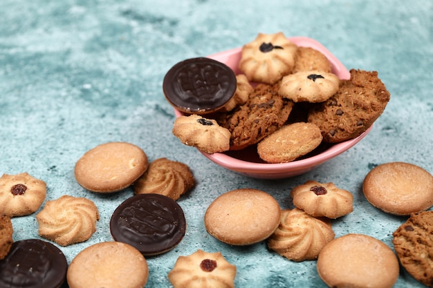 Galletas mixtas en un recipiente de color rosa.