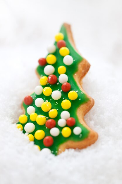 Galletas de Navidad, forma de árbol de Navidad esmaltado en una nieve, primer plano, enfoque selectivo