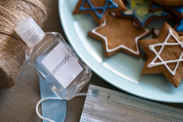 Foto gratuita galletas navideñas felices de hanukkah y desinfectante de manos